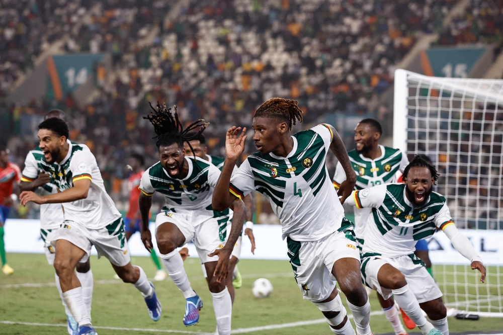 Cameroon's defender #4 Christopher Wooh celebrates scoring his team's third goal during the Africa Cup of Nations (CAN) 2024 group C football match between Gambia and Cameroon at Stade de la Paix in Bouake on January 23, 2024. (Photo by KENZO TRIBOUILLARD / AFP)