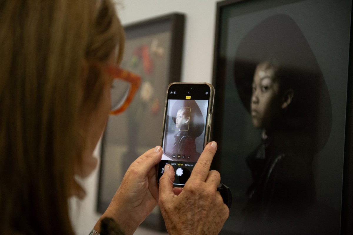 A woman takes a snapshot at the Sophie Scheidecker Gallery of France, during the inauguration of the 'Este arte' exhibition at Vik Pavilion in José Ignacio, Maldonado, Uruguay, on January 6, 2024. (Photo by Santiago Mazzarovich / AFP)
