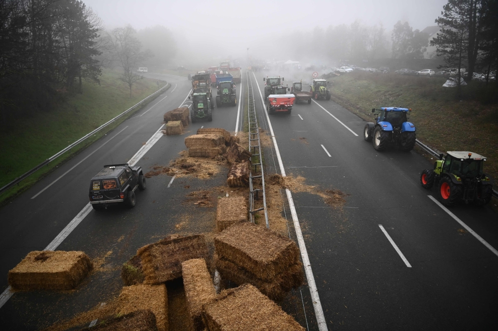 Farmers of the CR47 (Coordination rurale) union block the A62 motor way near Agen, southwerstern France, on January 25, 2024, as part of a nation-wide day of actions and road blockades called by several farming union to protest against increases in production costs and environmental regulations. Photo by Christophe ARCHAMBAULT / AFP