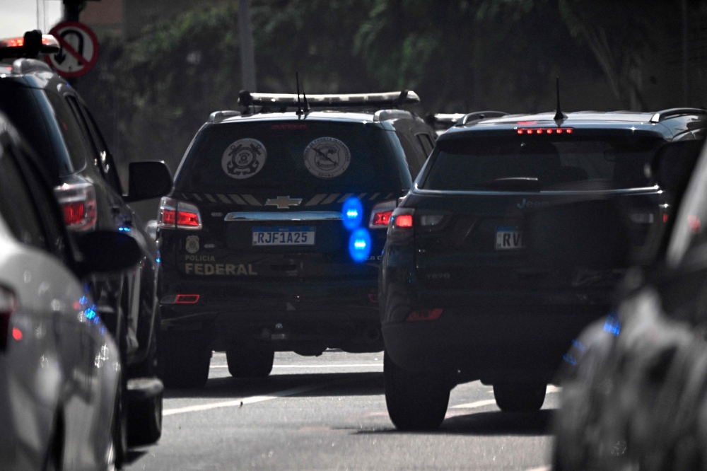 Federal Police vehicles drive on their way to the Federal Police headquarters after a raid on the house of councilman Carlos Bolsonaro in Rio de Janeiro, Brazil, on January 29, 2024. (Photo by MAURO PIMENTEL / AFP)
