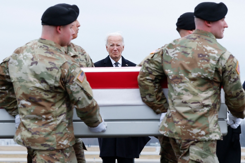US President Joe Biden places his hand over his heart while watching a US Army team move a flagged draped transfer case containing the remains of Army Sgt. William Rivers during a dignified transfer on February 02, 2024. Kevin Dietsch/Getty Images/AFP 