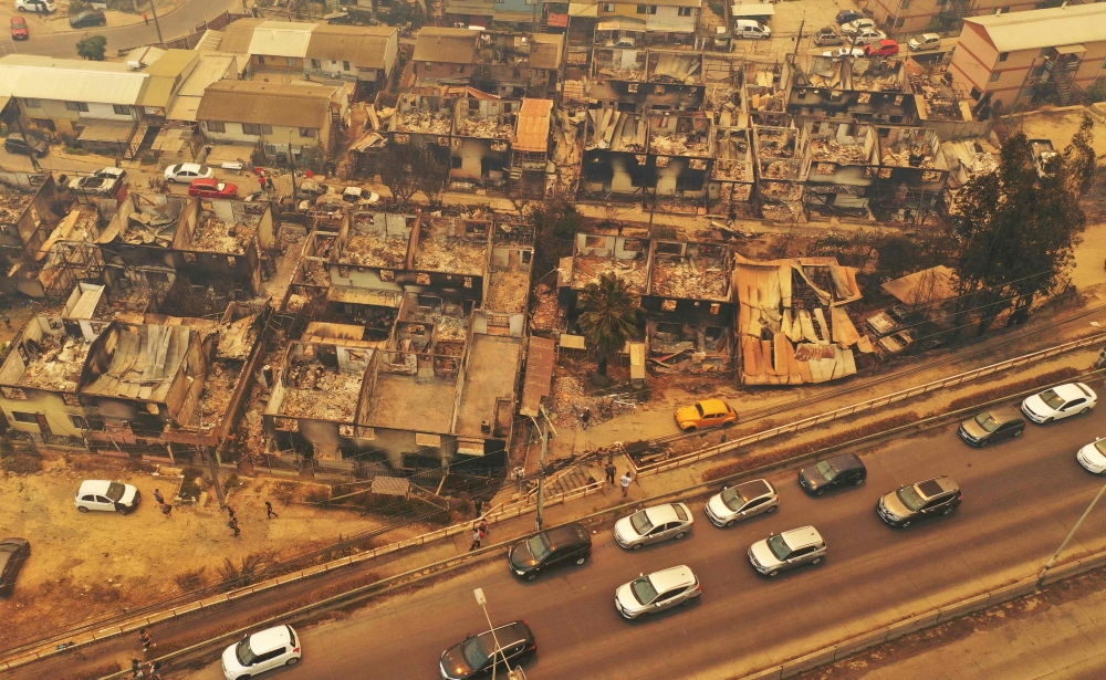 Aerial view of burned houses after a forest fire that affected the hills in Quilpe, Viٌa del Mar, Chile, taken on February 3, 2024. Photo by RODRIGO ARANGUA / AFP