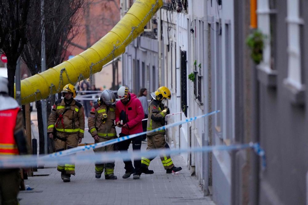 Firefighters inspect a building as emergency services are looking for potential victims after a habitation building has collapsed, in Badalona on February 6, 2024. (Photo by Pau Barrena / AFP)