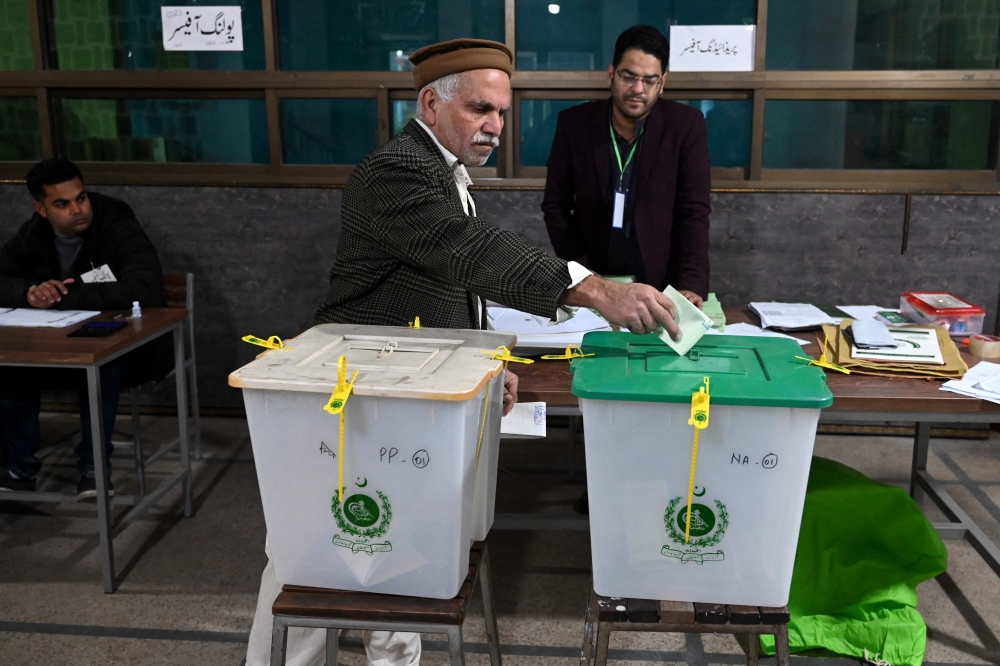 A man casts his ballot to vote at a polling station during Pakistan's national elections in Lahore on February 8, 2024. (Photo by Arif Ali / AFP)