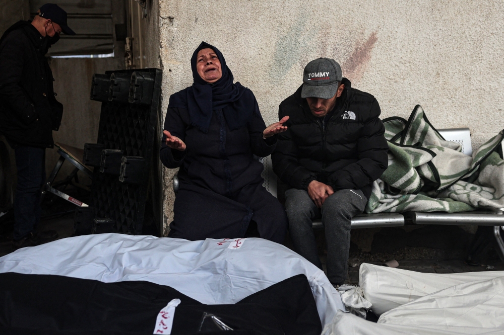 Palestinians mourn after identifying bodies of relatives killed in overnight Israeli bombardment on the southern Gaza Strip, at Al-Najjar hospital in Rafah, on February 10, 2024. (Photo by Said Khatib / AFP)