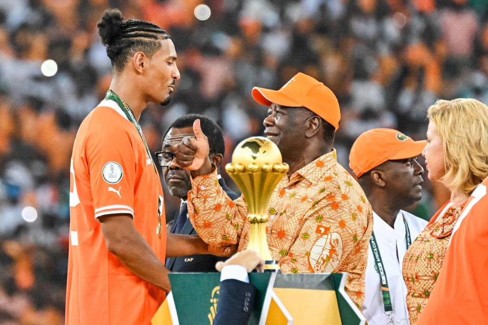 President of Ivory Coast Alassane Ouattara (C) congratulates Ivory Coast's forward #22 Sebastien Haller (L) after winning at the end of the Africa Cup of Nations (CAN) 2024 final football match between Ivory Coast and Nigeria at Alassane Ouattara Olympic Stadium in Ebimpe, Abidjan on February 11, 2024. (Photo by Sia Kambou / AFP)