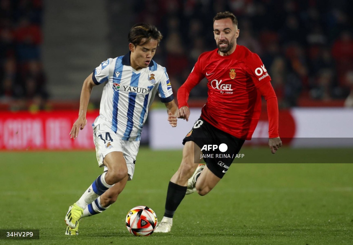 Real Sociedad's Japanese forward #14 Takefusa Kubo (L) vies with Real Mallorca’s Spanish midfielder #10 Sergi Darder during the Spanish Copa del Rey (King's Cup) semi final first leg football match between RCD Mallorca and Real Sociedad at the Mallorca Son Moix stadium in Palma de Mallorca on February 6, 2024. (Photo by JAIME REINA / AFP)