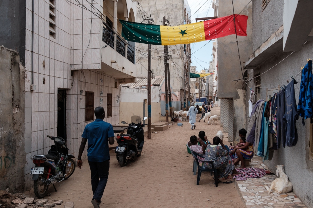 A large Senegalese flag hangs across a street in a neighbourhood in Dakar on February 13, 2024. (Photo by GUY PETERSON / AFP)

