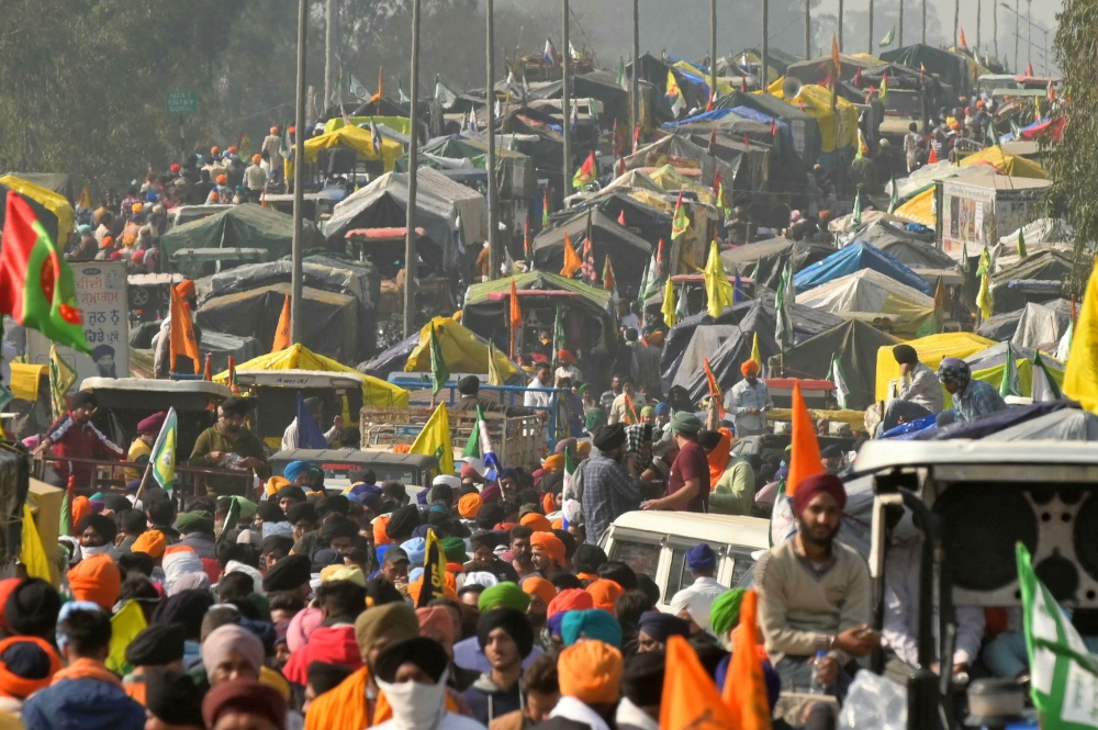 Farmers gather along a highway blocked by police to prevent them from marching towards New De;hi during a protest demanding minimum crop prices, near the Haryana-Punjab state border at Shambhu in Patiala district on February 16, 2024. (Photo by Narinder NANU / AFP)
