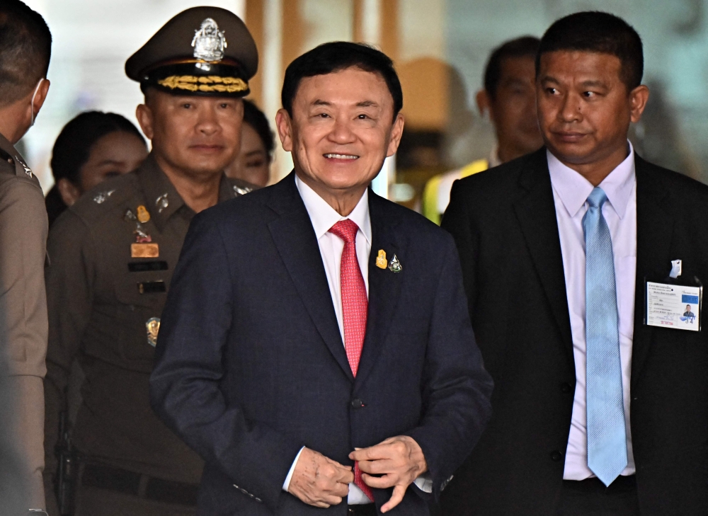 (Files) Former Thai Prime Minister Thaksin Shinawatra (C) arrives to greet his supporters after landing at Don Mueang Airport in Bangkok on August 22, 2023. (Photo by Lillian Suwanrumpha / AFP)