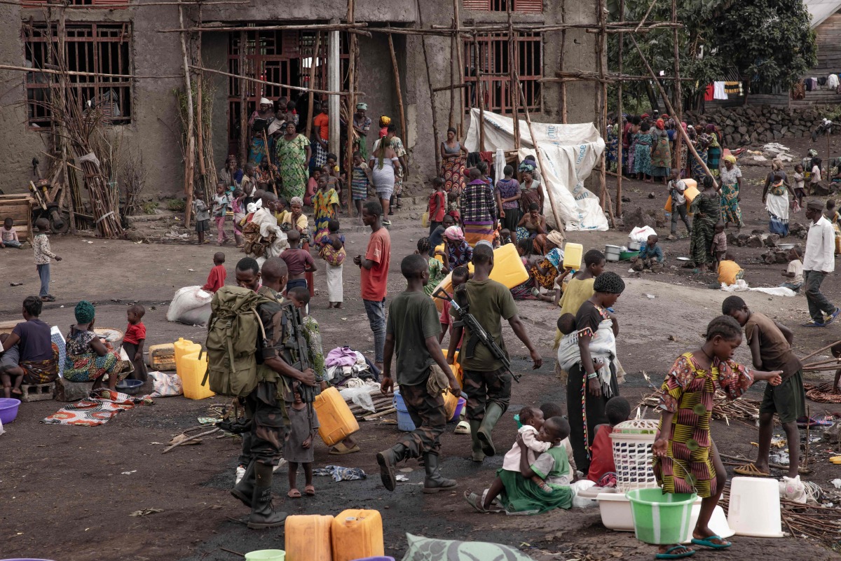 Congolese army soldiers walk along the side of the Bulengo camp a few kilometres from the centre of Goma, on February 16, 2024. . (Photo by Guerchom Ndebo / AFP)