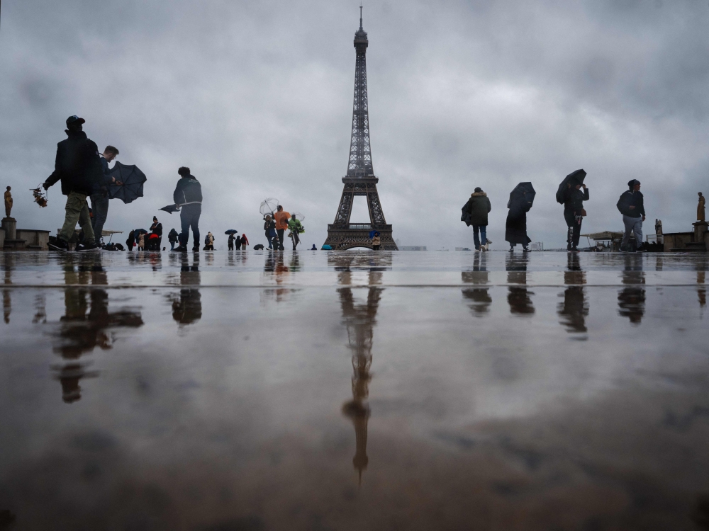 Visitors walk at the Esplanade du Trocadero with the Eiffel Tower in the background, which is closed to the public on the fourth day of its staff's strike, in Paris on February 22, 2024. (Photo by Dimitar Dilkoff / AFP)