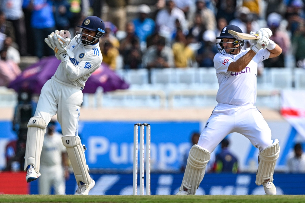 England's Joe Root (R) plays a shot during the second day of the fourth Test cricket match between India and England at the Jharkhand State Cricket Association (JSCA) Stadium in Ranchi on February 24, 2024. (Photo by Tauseef Mustafa / AFP)
