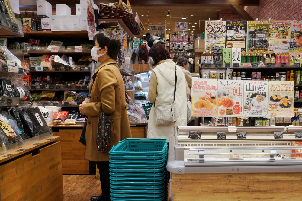 Customers gather at a souvenir shop that sells local seafood in Tokyo on February 27, 2024. (Photo by Kazuhiro NOGI / AFP)
