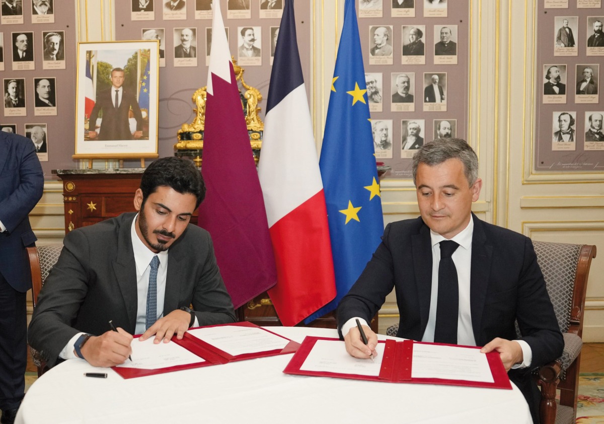 Minister of Interior and Commander of the Internal Security Force (Lekhwiya) H E Sheikh Khalifa bin Hamad bin Khalifa Al Thani (left) and French Minister of Interior and Overseas Territories H E Gerald Darmanin sign a document.