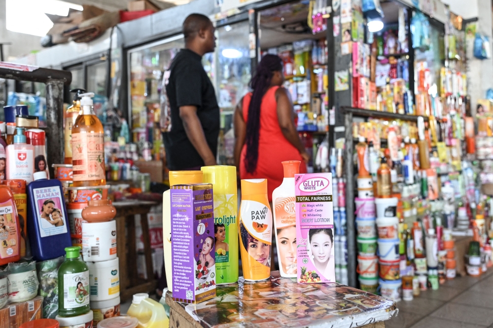 Customers approach a shop selling skin lightening cosmetic products at the Koumassi market, in Abidjan on February 26, 2024. (Photo by Sia Kambou / AFP)