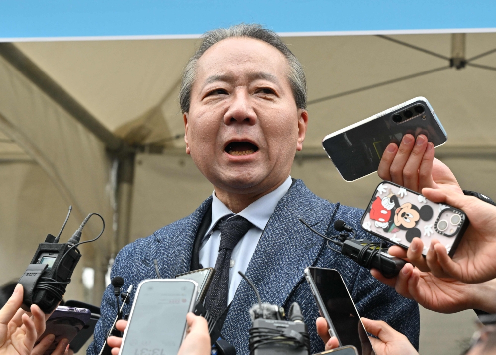 This picture taken on March 3, 2024 shows Joo Soo-ho (C), a spokesperson of the Korean Medical Association (KMA), speaking to reporters during a mass rally of doctors opposing the government's plans to sharply increase medical school admissions, in Seoul. (Photo by Jung Yeon-je / AFP)