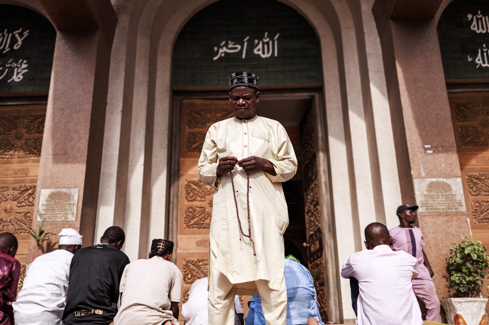A man prays in front of the Lagos Central Mosque in Lagos on March 8, 2024, ahead of the holy fasting month of Ramadan. (Photo by Benson Ibeabuchi / AFP)

