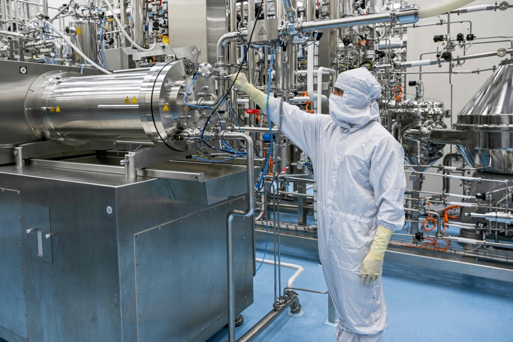 In this photograph taken on February 27, 2024, a staff works inside the Human Papillomavirus (HPV) vaccine manufacturing unit of the Serum Institute of India (SII) at its headquarters in Hadapsar, Pune. (Photo by Indranil MUKHERJEE / AFP)
