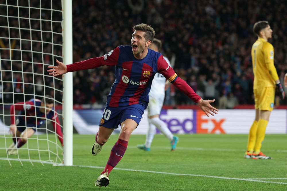 Barcelona's Spanish midfielder #20 Sergi Roberto celebrates a goal scored by Barcelona's Polish forward #09 Robert Lewandowski (L) during the UEFA Champions League last 16 second leg football match between FC Barcelona and SSC Napoli at the Estadi Olimpic Lluis Companys in Barcelona on March 12, 2024. (Photo by LLUIS GENE / AFP)

