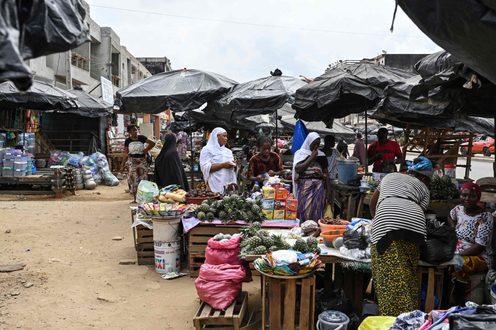 People shop at the market in Abobo, a suburb of Abidjan on March 14, 2024. (Photo by Issouf SANOGO / AFP)
