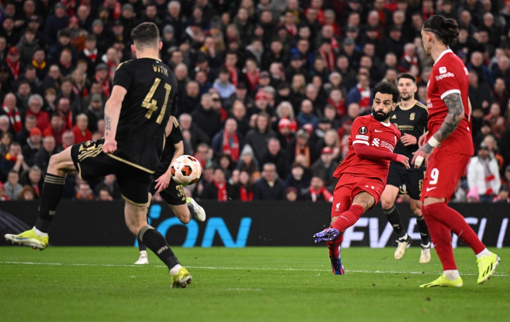Liverpool's Egyptian striker #11 Mohamed Salah scores the team's third goal during the UEFA Europa League round of 16 second leg football match between Liverpool and AC Sparta Praha at Anfield in Liverpool, north west England on March 14, 2024. (Photo by Oli Scarff / AFP)