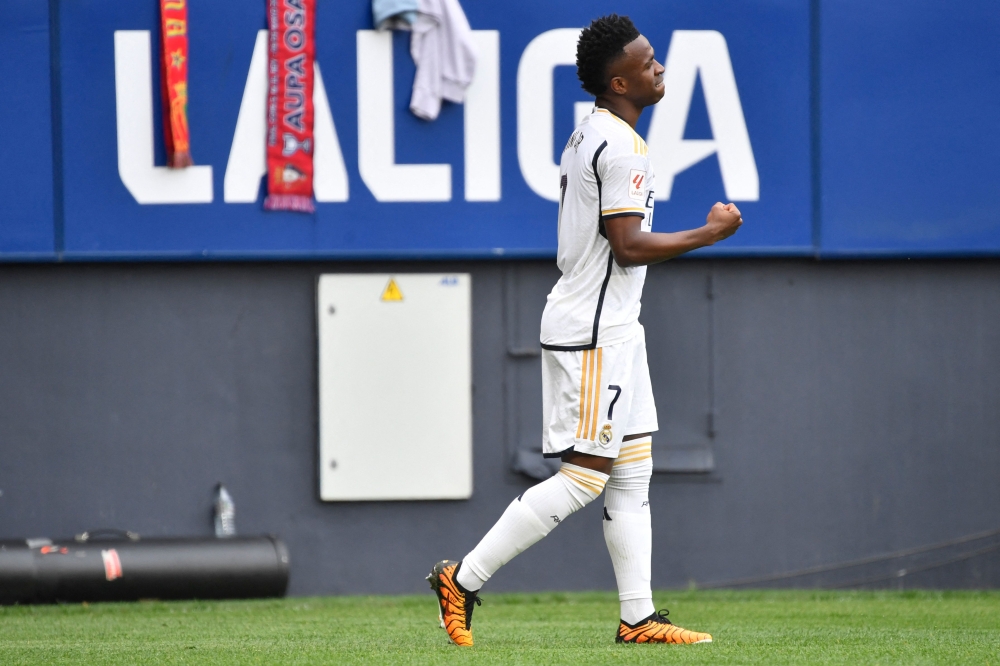 Real Madrid's Brazilian forward #07 Vinicius Junior celebrates scoring the opening goal with Real Madrid's Brazilian forward #11 Rodrygo during the Spanish league football match between CA Osasuna and Real Madrid CF at El Sadar stadium in Pamplona on March 16, 2024. (Photo by Ander Gillenea / AFP)

