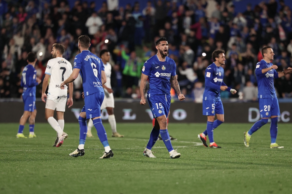 Getafe's Paraguayan defender #15 Omar Alderete and teammates celebrate their win at the end of the Spanish league football match between Getafe CF and Girona FC at the Col. Alfonso Perez stadium in Getafe on March 16, 2024. (Photo by Thomas COEX / AFP)

