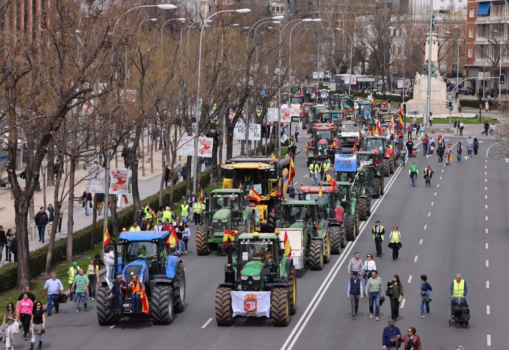 Farmers drive their tractors during a protest organised by 
