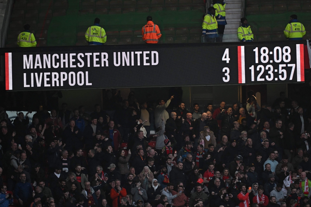 The scoreboard displays the final score after extra-time in the English FA Cup Quarter Final football match between Manchester United and Liverpool at Old Trafford in Manchester, north west England, on March 17, 2024. Manchester United won the game 4-3 after extra-time. (Photo by Paul ELLIS / AFP)