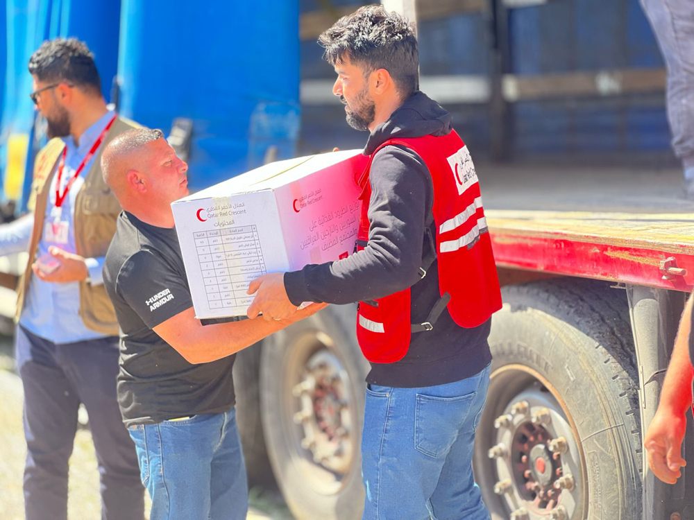  QRCS staff distribute food items to the needy during one of their international outreaches recently.