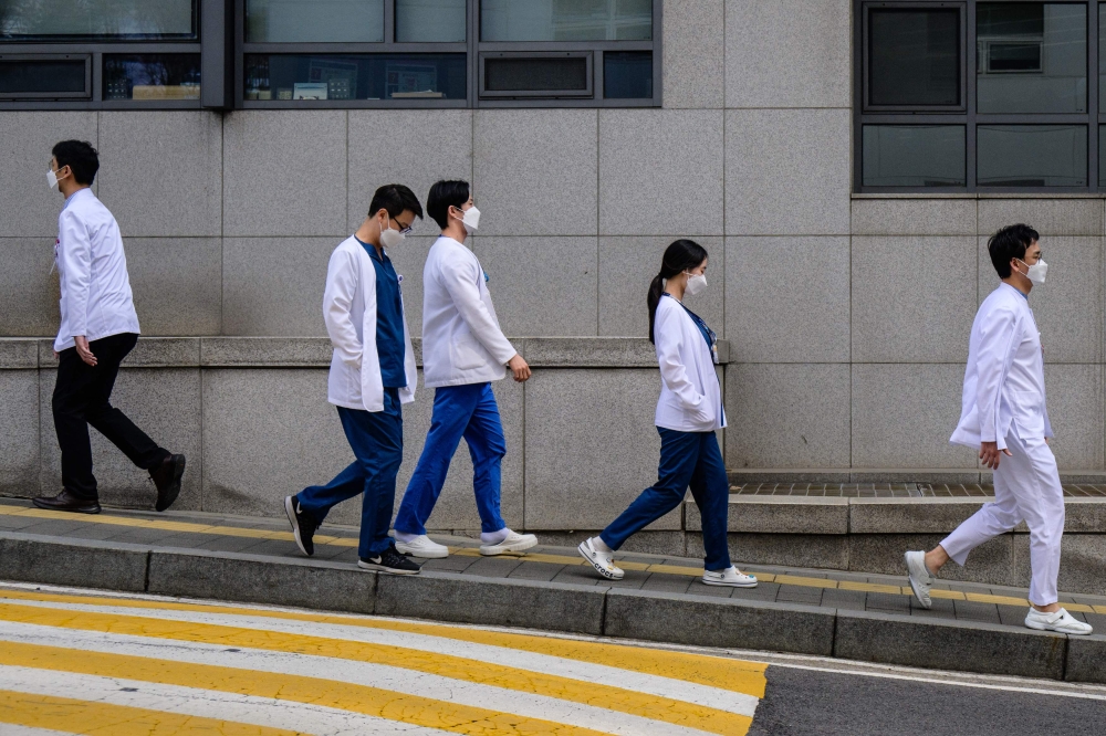 Medical workers walk outside a hospital in Seoul on March 19, 2024. Photo by ANTHONY WALLACE / AFP