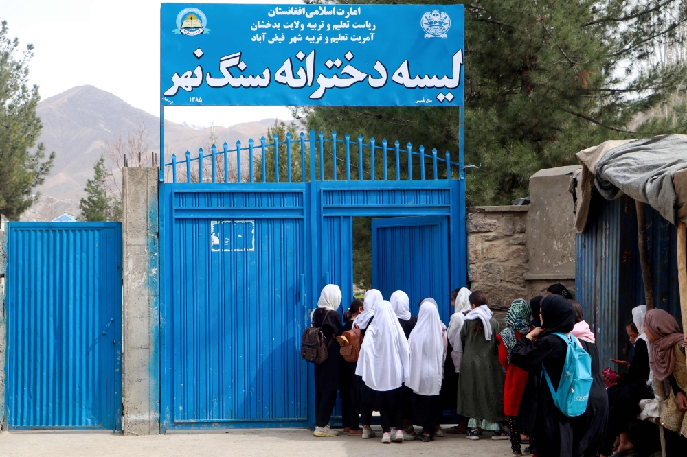 Afghan primary school girls arrive for their first class following the start of the new academic year, at a school in Fayzabad district, Badakhshan province on March 20, 2024. Schools in Afghanistan opened for the new academic year on March 20, the education ministry said, with girls banned from joining secondary-level classes for the third year in a row. Photo Credit: OMER ABRAR / AFP.