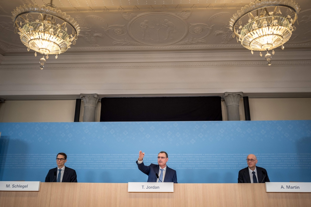 Chairman of Swiss National Bank (SNB BNS) Thomas Jordan (C) gestures next to Vice Chairman Martin Schlegel (L) and board member Antoine Martin (R) during a press conference of the Swiss Central Bank on monetary policy assessment, in Zurich on March 21, 2024. (Photo by Fabrice COFFRINI / AFP)
