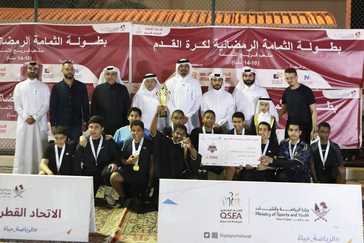 Triumphant Al Janoubia players along with officials pose with the trophy. 