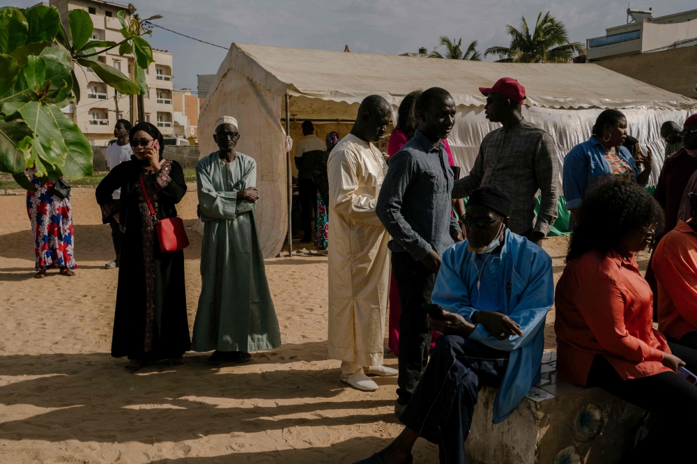 People queue at a polling station in a school in HLM Grand Medine on the outskirts of Dakar, on March 24, 2024 during the Senegalese presidential elections. (Photo by Carmen Abd Ali / AFP)