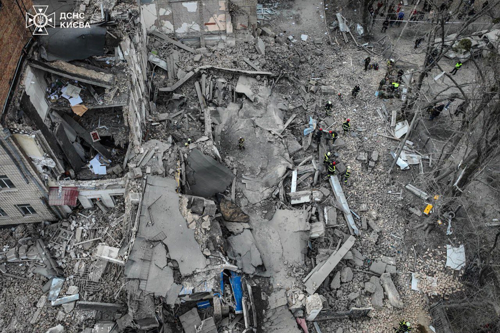 A Ukrainian rescuer works at the site of a missile attack in Kyiv on March 25, 2024. Photo Credit: Sergei SUPINSKY / AFP. 
