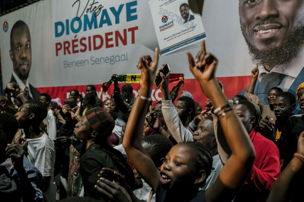 People gather outside anti-establishment candidate Bassirou Diomaye Faye's headquarters in Dakar on March 24, 2024 as results remain expected during the Senegalese presidential elections. Photo by Carmen Abd Ali / AFP. 