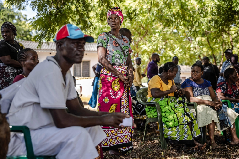 Members of a family gather under a tree while waiting to receive the remains of several family members who were victims of a Kenyan starvation cult at the Malindi Sub-County Hospital Mortuary in Malindi on March 26, 2024. (Photo by Luis Tato / AFP)