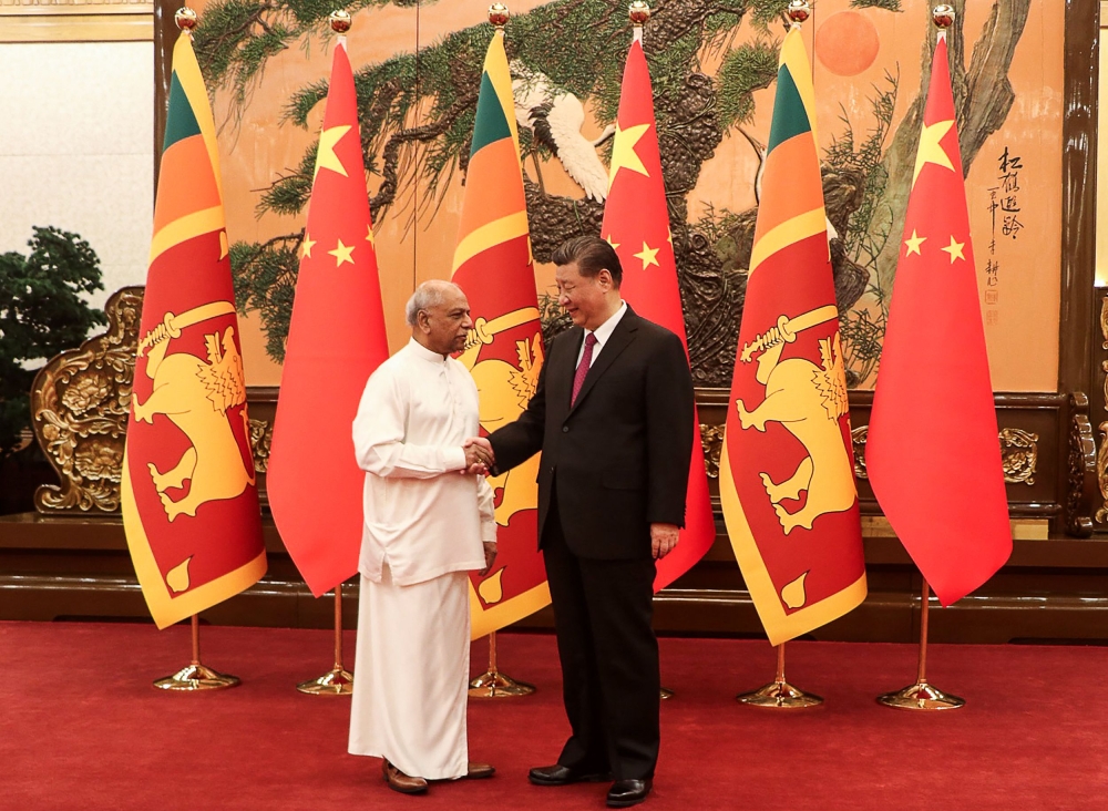 photograph released by Sri Lanka Prime Minister's Office on March 27, 2024 shows Sri Lanka's Prime Minister Dinesh Gunawardena (L) shaking hands with China's President Xi Jinping before a meeting in Beijing. Photo by Sri Lanka Prime Minister's Office / AFP. 