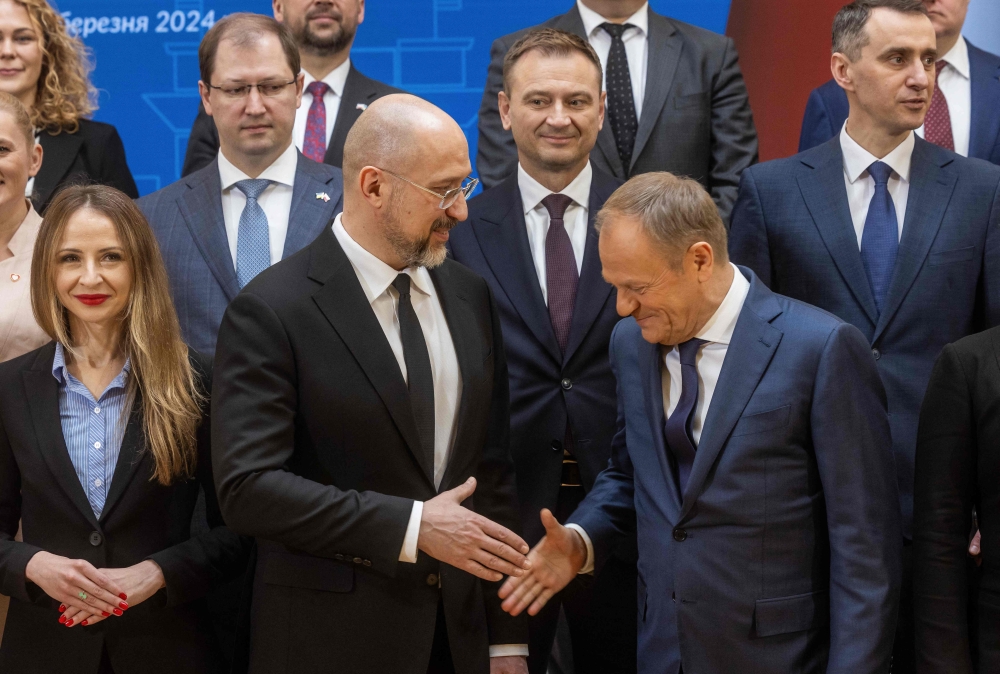 Ukraine's Prime Minister Denys Shmyhal (C) and Polish Prime Minister Donald Tusk (R) shakes hands during the family photo of the Ukrainian and Polish delegations during Polish-Ukraine Government Consultation at the Polish Prime Ministry office in Warsaw, March 28, 2024. Photo by Wojtek Radwanski / AFP.
 