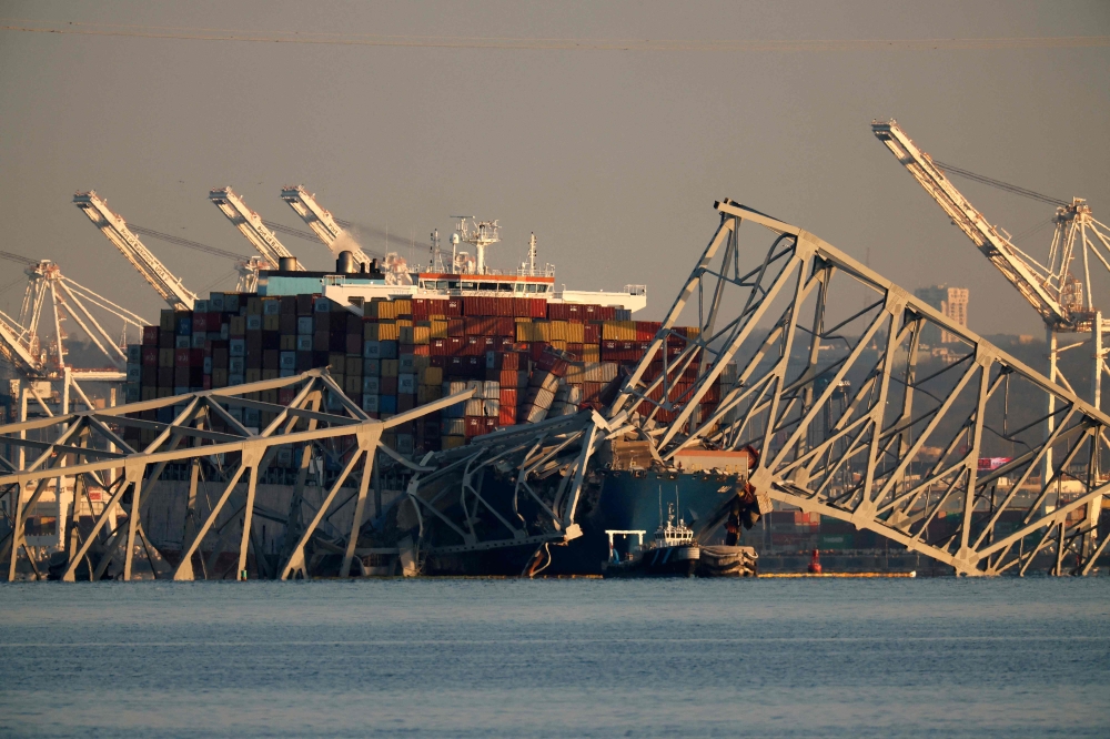 The cargo ship Dali remains trapped under the twisted remains of the Francis Scott Key Bridge, which was destroyed when the ship collided with it earlier this week, on March 29, 2024 in Baltimore, Maryland. Photo by CHIP SOMODEVILLA / GETTY IMAGES NORTH AMERICA / Getty Images via AFP