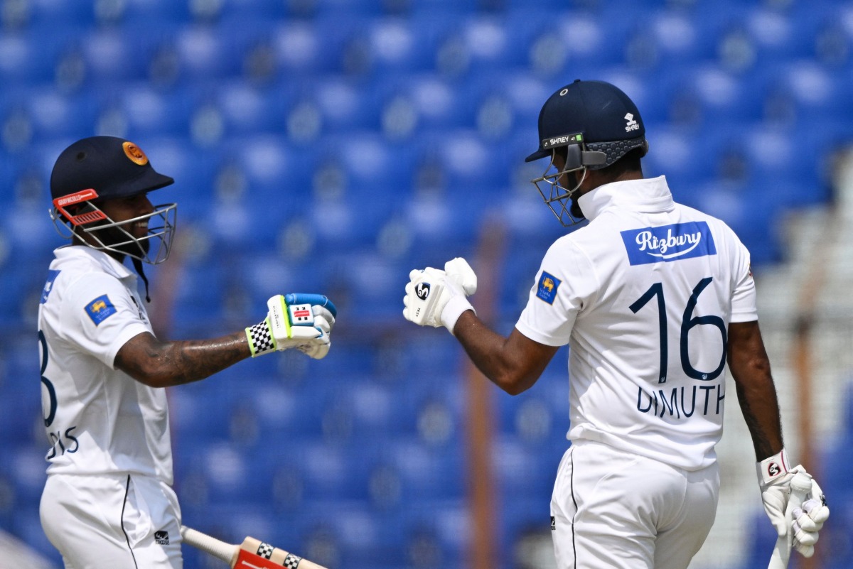 Dimuth Karunaratne (R) celebrates with teammate Kusal Mendis (L) after scoring a half century (50 runs) during the first day of the second Test cricket match between Bangladesh and Sri Lanka at the Zahur Ahmed Chowdhury Stadium in Chittagong on March 30, 2024. (Photo by MUNIR UZ ZAMAN / AFP)

