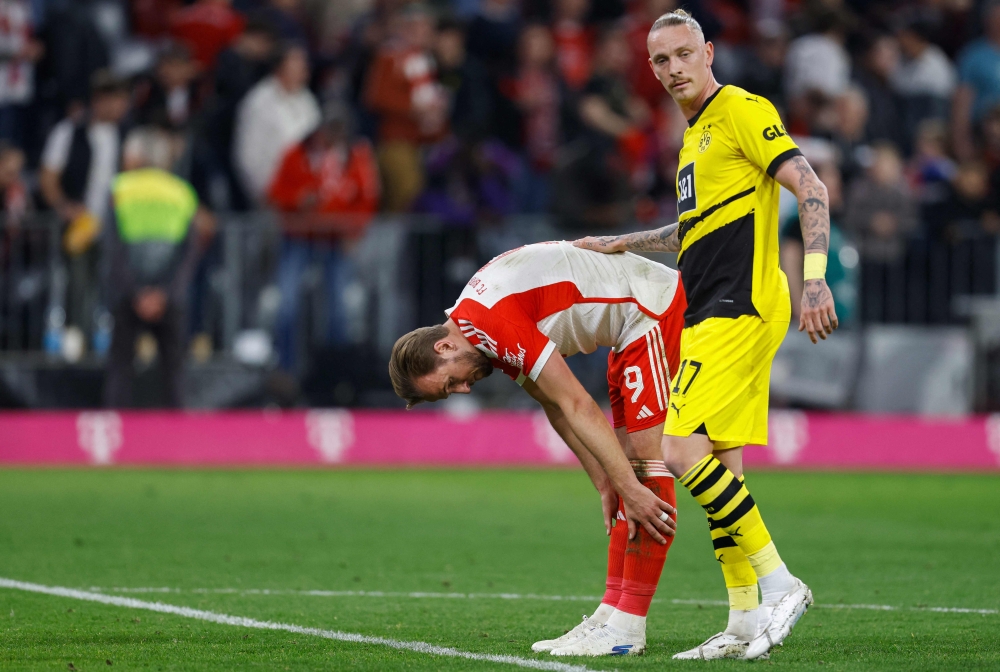 Bayern Munich's English forward #09 Harry Kane and Dortmund's German midfielder #17 Marius Wolf (R) react after the German first division Bundesliga football match FC Bayern Munich v BVB Borussia Dortmund in Munich, southern Germany on March 30, 2024 (Photo by ALEXANDRA BEIER / AFP)
