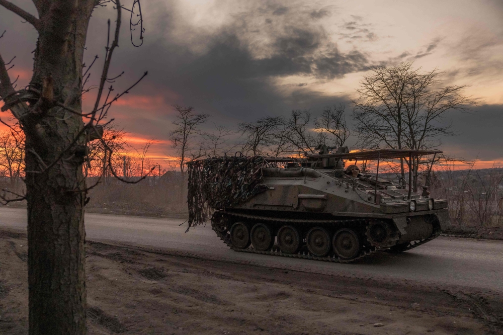 A Ukrainian serviceman drives a British FV103 Spartan armoured personnel carrier on a road that leads to the town of Chasiv Yar, in the Donetsk region, on March 30, 2024, amid the Russian invasion of Ukraine. (Photo by Roman PILIPEY / AFP)
