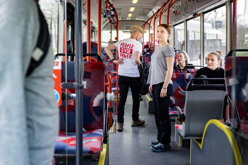 Swedish climate activist Greta Thunberg stands in a public service bus after taking part in a climate march against fossil subsidies near the highway A12 in the Hague, on April 6, 2024. (Photo by Ramon van Flymen / ANP / AFP) 