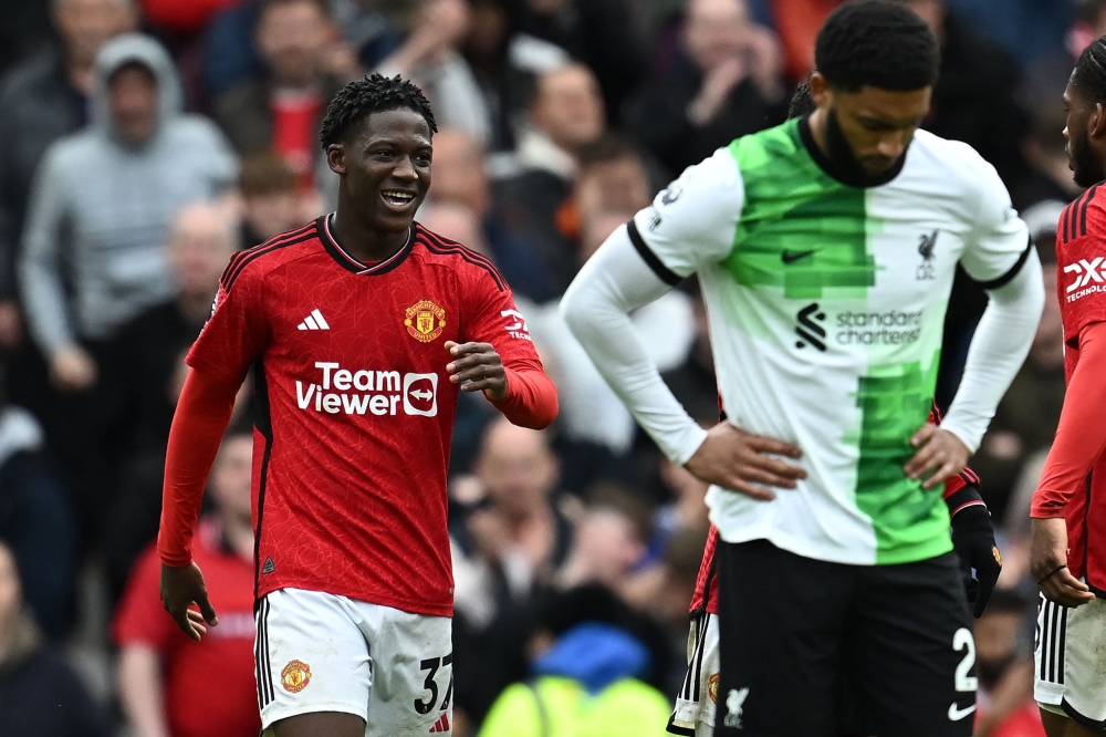 Manchester United's English midfielder #37 Kobbie Mainoo (L) celebrates after scoring their second goal during the English Premier League football match between Manchester United and Liverpool at Old Trafford in Manchester, north west England, on April 7, 2024. (Photo by Paul ELLIS / AFP)