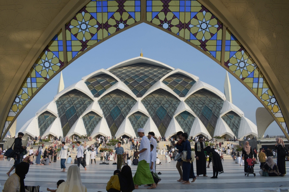 Muslims walk after attending Eid al-Fitr prayers, marking the end of the holy month of Ramadan, at Al Jabbar mosque in Bandung, West Java, on April 10, 2024. (Photo by Timur Matahari / AFP)
