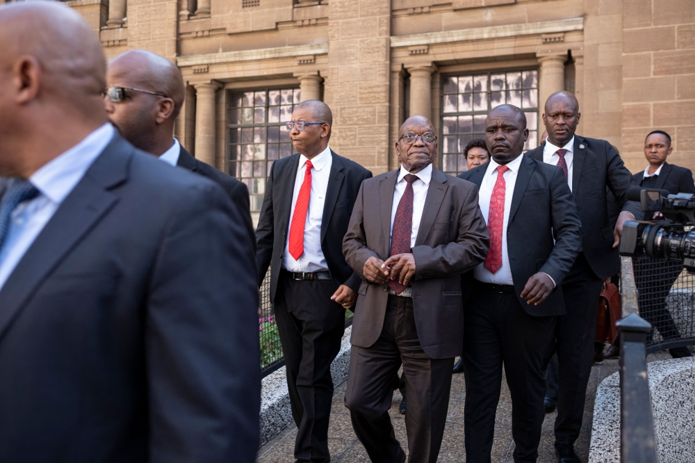 Former South African President Jacob Zuma (C) walks out of court after the private prosecution trial, where Zuma is suing South African President Cyril Ramaphosa over a leaked medical report linked to a 1990s arms corruption trial, in Johannesburg on April 11, 2024. (Photo by EMMANUEL CROSET / AFP)
