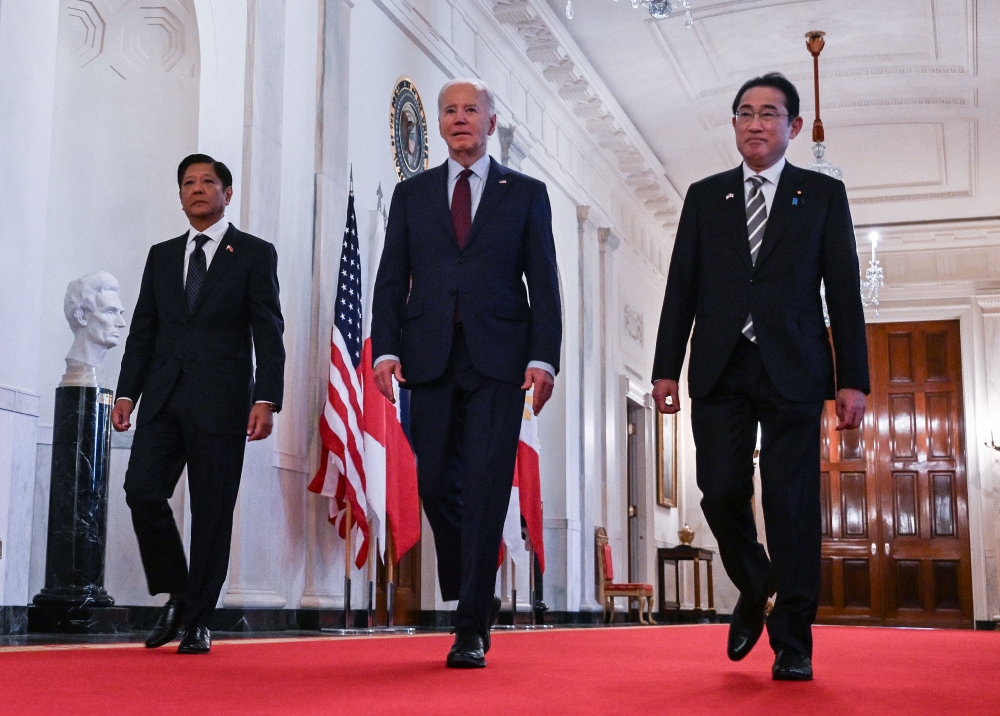 US President Joe Biden heads to a trilateral meeting with Japanese Prime Minister Fumio Kishida (right) and Filipino President Ferdinand Marcos Jr at the White House in Washington, DC, on April 11, 2024. (Photo by Andrew Caballero-Reynolds / AFP)
